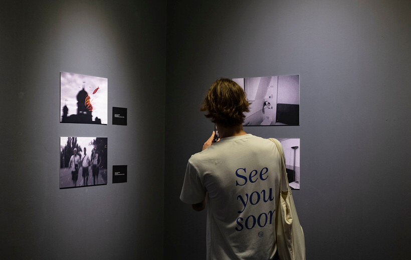 A visitor looking at framed works